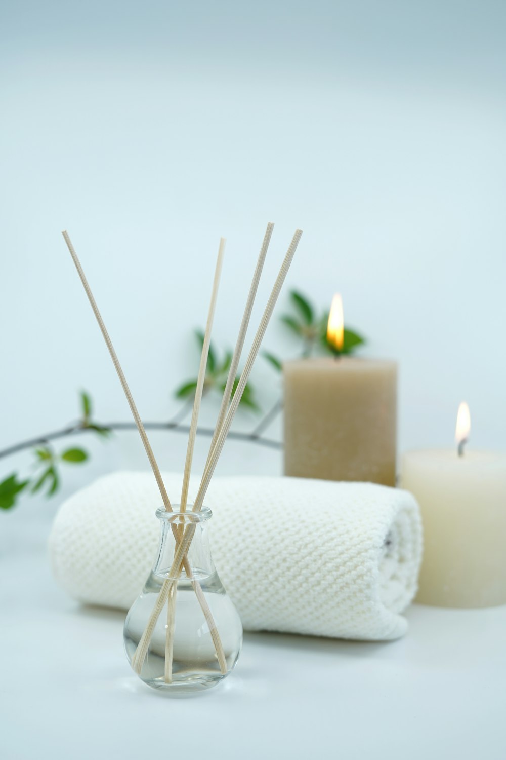 Candles, a reed diffuser and a rolled towel